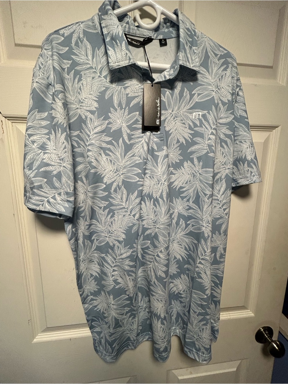 Travis Mathew Men’s Sea Journey Light Blue Polo with White Tropical Leaf Print